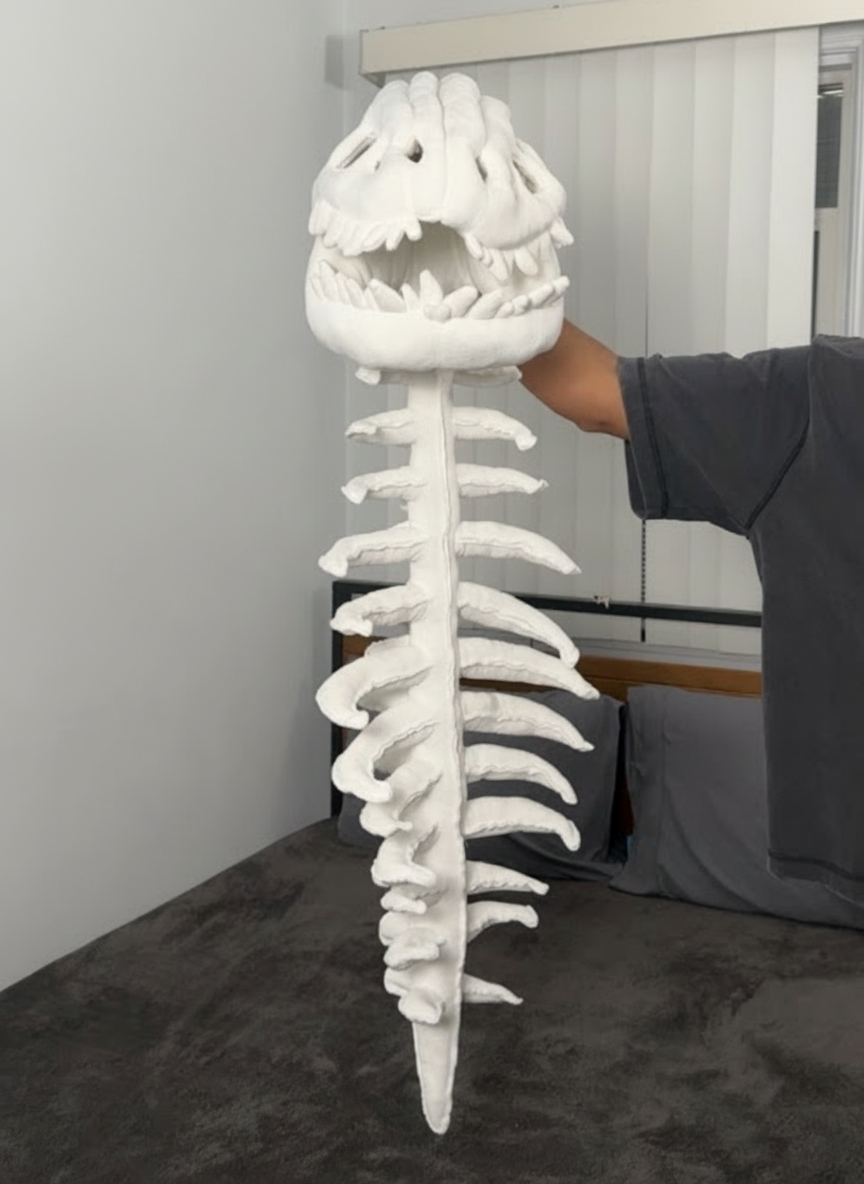 Peluche DinoHuesitos dinosaurio esquelético color blanco con detalles bordados, vista frontal